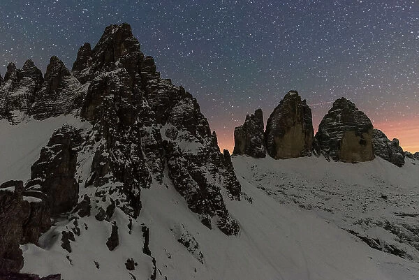 Starry night over Tre Cime di Lavaredo (Lavaredo peaks) and Paterno mountain, winter view, Sesto (Sexten), Dolomites, South Tyrol, Italy, Europe