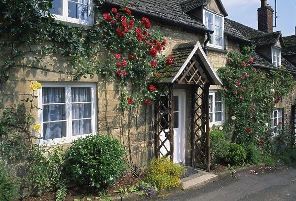 Stone cottages with roses on the walls in the Cotswolds village of Winchcombe