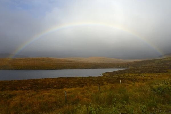 Stormy sky and rainbow over a Loch, Highlands, Scotland, United Kingdom, Europe