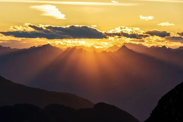 Sun rays at sunset on Pizzo Berro and Gerola Valley seen from San Marco Pass, Orobie Alps