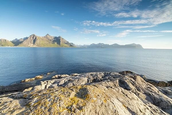 Sun shines on the blue sea and the rocky peaks at night during summer, Vikten, Nord Trondelag