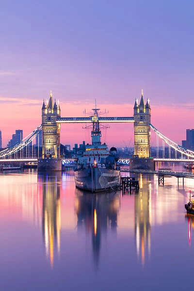 Sunrise view of HMS Belfast and Tower Bridge reflected in River Thames