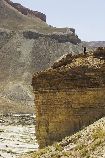 Tourist standing on rock cliff looking at Band-I-Zulfiqar the main lake