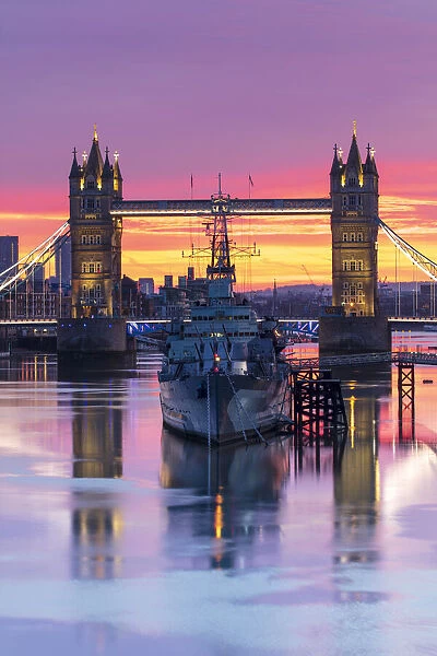 Tower Bridge and HMS Belfast reflecting in a still River Thames at sunset, London, England, United Kingdom, Europe
