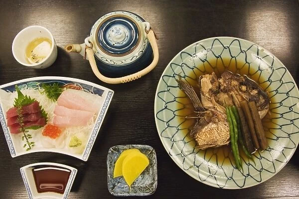 A traditional Japanese meal of sushi and fish head