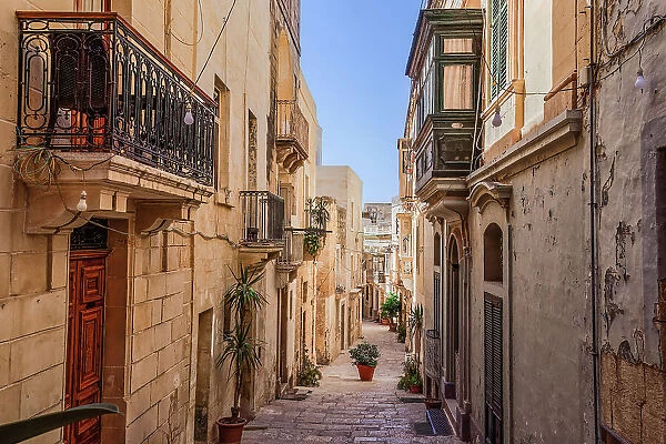 Traditional Maltese limestone buildings with coloured balconies in the vibrant alleys of the old city of Birgu (Citta Vittoriosa), Malta, Mediterranean, Europe