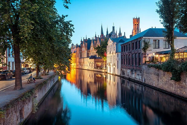 A tranquil canal scene in Bruges, with the spires of the Stadhuis (Town Hall) in the
