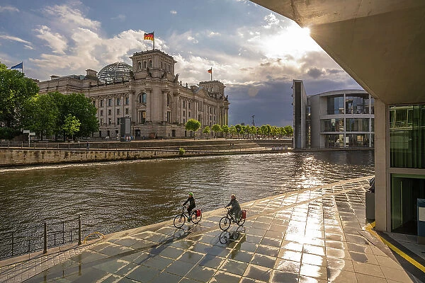 View of cyclists and River Spree and the Reichstag (German Parliament building), Mitte, Berlin, Germany, Europe