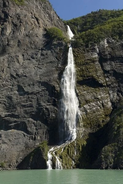 Waterfall from hanging valley, over fjord of Ultima Esperanza, Puerto Natales, Patagonia, Chile, South America