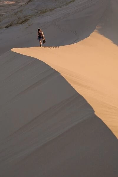 Woman walking through Kelso Dunes, Mojave Desert National Reserve, California