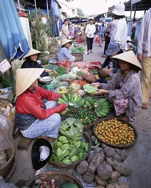 Women in conical hats selling fruit and vegetables