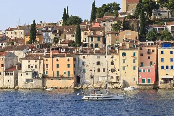 Yacht and Old Town from the sea on a summers early morning, Rovinj (Rovigno) peninsula, Istria, Croatia, Europe