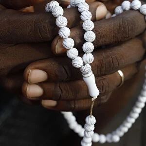 Close-up of hands of African Muslim man praying with Islamic prayer beads (tasbih), Togo