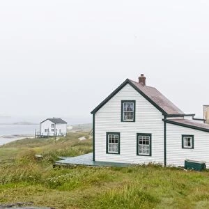 Fog rolls in over the small preserved fishing village of Battle Harbour, Labrador, Canada, North America