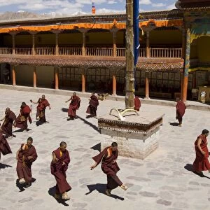 Group of monks dancing in the monastery courtyard rehearsing