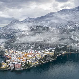 Mist over Varenna old town and Lake Como after a snowfall in winter, aerial view