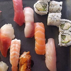 Plate of sushi covered with raw fish and stuffed