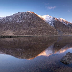 Snow capped Highlands mountains reflected in the calm waters of Loch Etive in winter