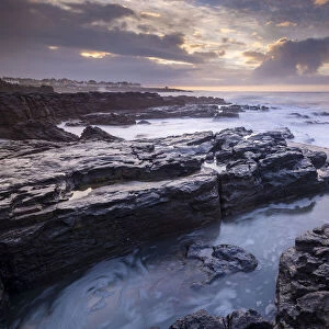 Sunrise over the dramatic rocky coastline of Porthcawl in winter, South Wales