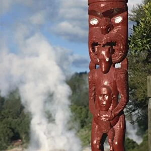 Traditional Maori carving and Pohutu geyser, Whakarewarewa, Rotorua, North Island