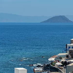 View of sea and whitewashed buildings and rooftops of Mandraki, Mandraki, Nisyros, Dodecanese, Greek Islands, Greece, Europe