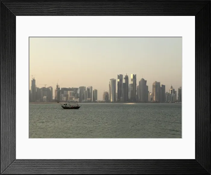 Framed Print : A traditional wooden dhow boat sails past modern skyscrapers in the West Bay financial district of Doha, Qatar, Middle East Framed Print : A traditional wooden dhow boat sails past modern skyscrapers in the West Bay financial district of Doha, Qatar, Middle East