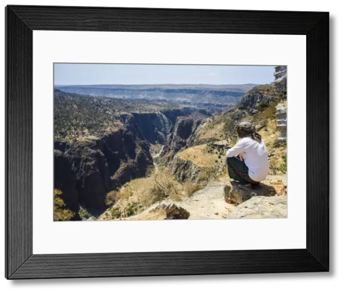 Framed Print : Local man looking at a huge canyon on the Dixsam plateau on the island of Socotra, UNESCO World Heritage Site, Yemen, Middle East Framed Print : Local man looking at a huge canyon on the Dixsam plateau on the island of Socotra, UNESCO World Heritage Site, Yemen, Middle East
