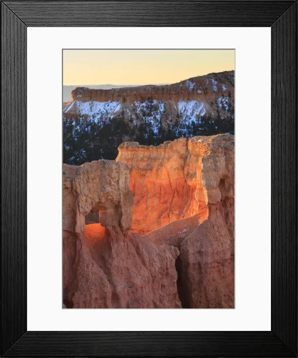 Framed Print : Rocks lit by strong dawn light, snowy backdrop, Queens Garden Trail at Sunrise Point, Bryce Canyon National Park, Utah, United States of America, North America