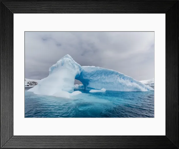 Framed Print : Archway formed in a glacial iceberg at Cierva Cove, Antarctica, Polar Regions