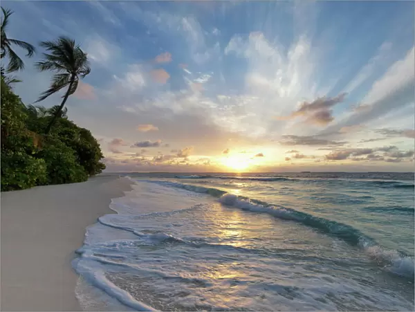 Sunrise over the Indian Ocean from a deserted beach in the Northern Huvadhu Atoll, Maldives, Indian Ocean, Asia