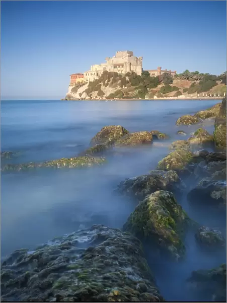 Alongside a picturesque millstone, atop a rocky promontory dominating the sea, rises the Castello di Falconara, Sicily, Italy, Mediterranean, Europe