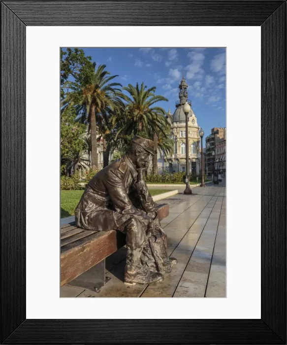Framed Print : Bronze statue of a sailor on a wooden bench with palm trees, Town Hall backdrop, Cartagena Framed Print : Bronze statue of a sailor on a wooden bench with palm trees, Town Hall backdrop, Cartagena