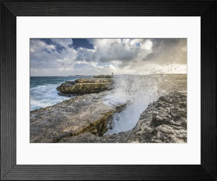 Framed Print : A wave created by the strong wind squirts water over Devils Bridge, a coral bridge created by wind Framed Print : A wave created by the strong wind squirts water over Devils Bridge, a coral bridge created by wind