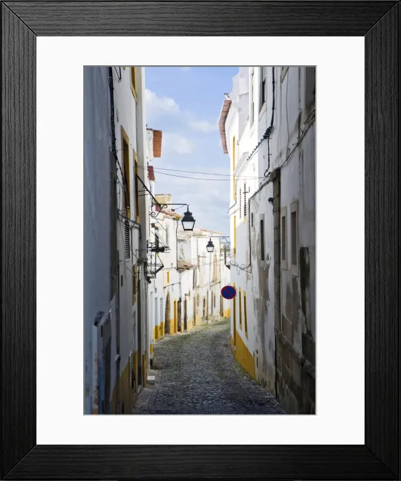 Framed Print : View along the medieval cobbled street of Rua do Moeda in historic centre of Evora Framed Print : View along the medieval cobbled street of Rua do Moeda in historic centre of Evora