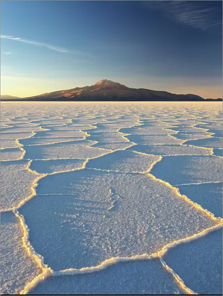 An Andean volcano rises above the Salar de Uyuni, the incredible salt desert, during