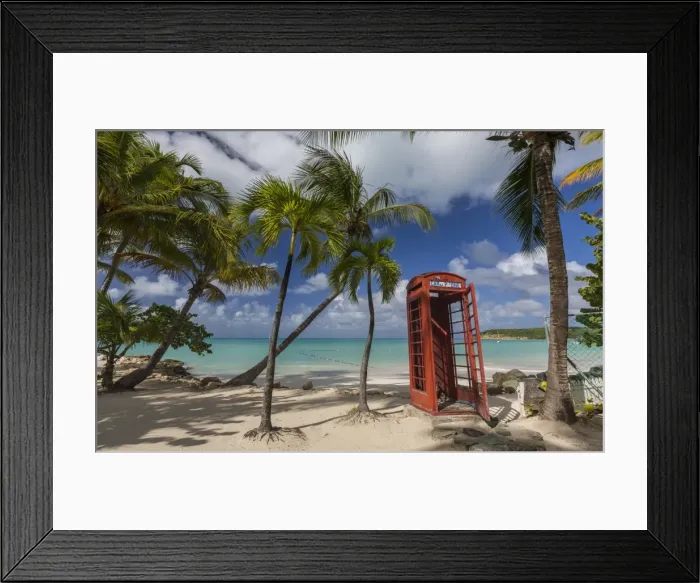 Framed Print : A red telephone box lies abandoned under coconut trees that surround Dickenson Bay Framed Print : A red telephone box lies abandoned under coconut trees that surround Dickenson Bay