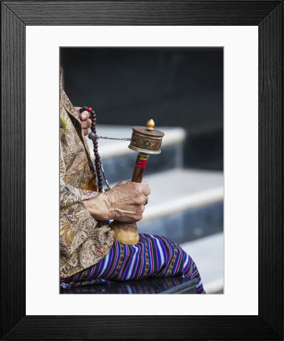 Framed Print : A faithful Buddhist uses the traditional portable roller-book (prayer wheel), Bhutan Framed Print : A faithful Buddhist uses the traditional portable roller-book (prayer wheel), Bhutan