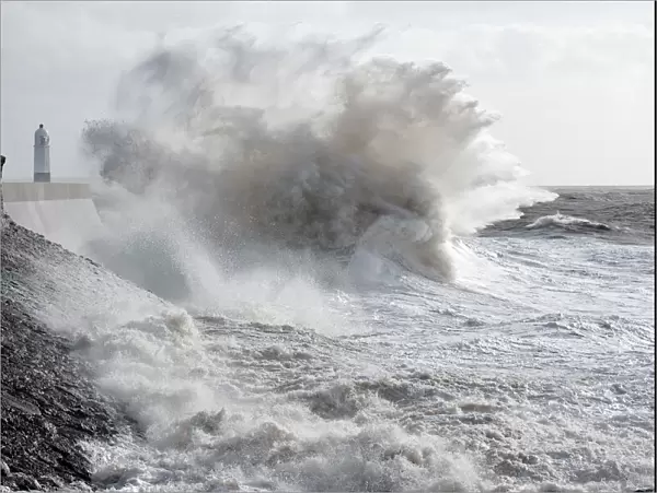 Waves crash against the harbour wall at Porthcawl, Bridgend, Wales, United Kingdom