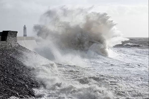 Waves crash against the harbour wall at Porthcawl, Bridgend, Wales, United Kingdom