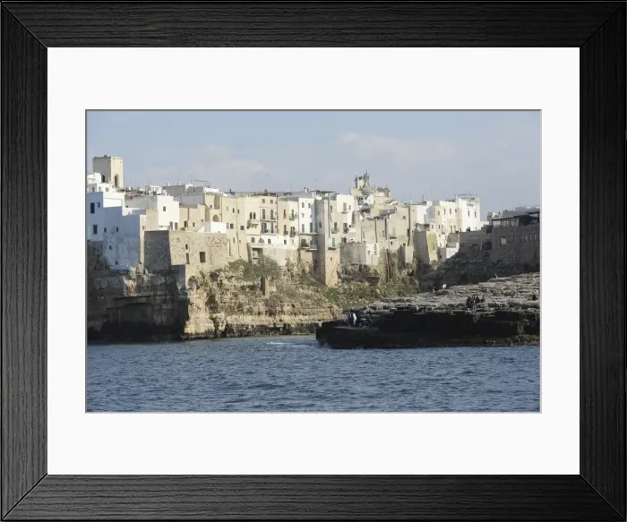 Framed Print : Clifftop houses, built onto rocks, surround the natural cove forming the harbour Framed Print : Clifftop houses, built onto rocks, surround the natural cove forming the harbour