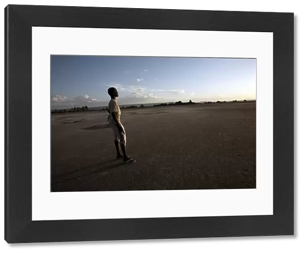 A boy stands in the desolate landscape of Lac Abbe, Djibouti, Africa