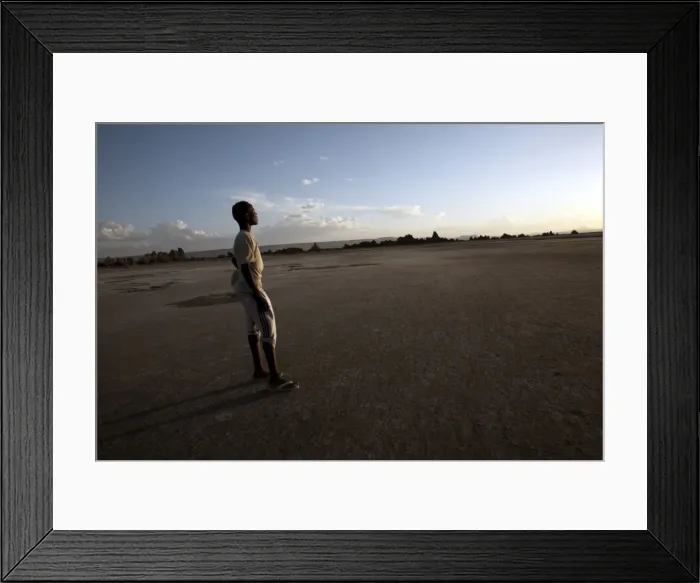 Framed Print : A boy stands in the desolate landscape of Lac Abbe, Djibouti, Africa Framed Print : A boy stands in the desolate landscape of Lac Abbe, Djibouti, Africa
