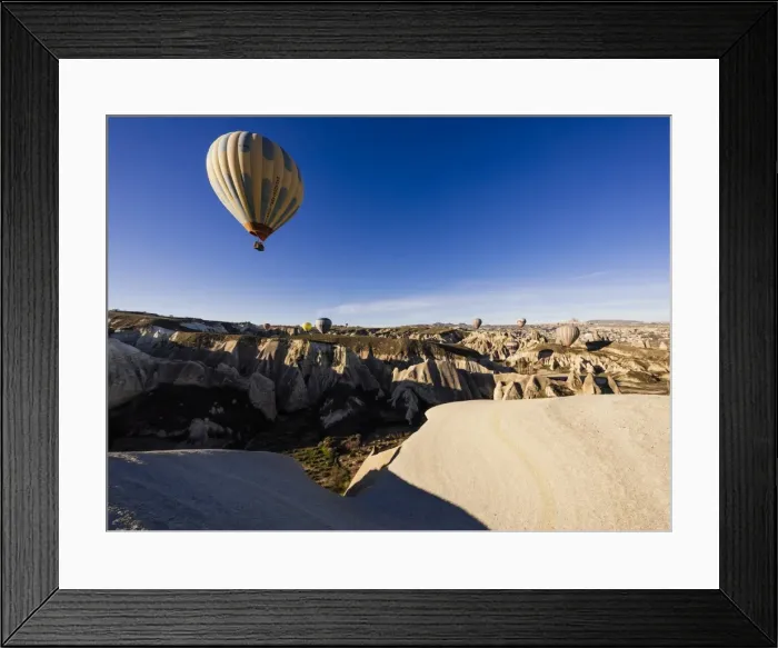 Framed Print : Hot air balloons flying among rock formations at sunrise in the Red Valley, Goreme National Park Framed Print : Hot air balloons flying among rock formations at sunrise in the Red Valley, Goreme National Park