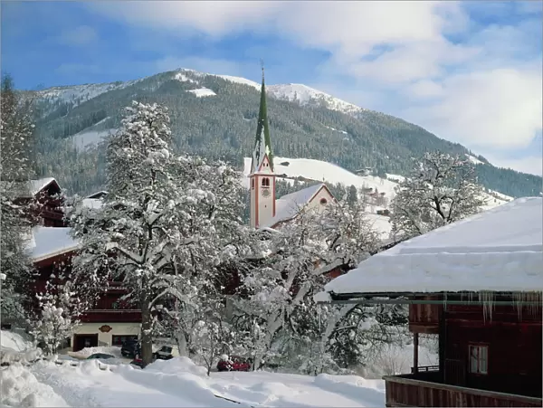 Snow covers the village and church of Alpbach in the Tyrol in the winter, Austria, Europe