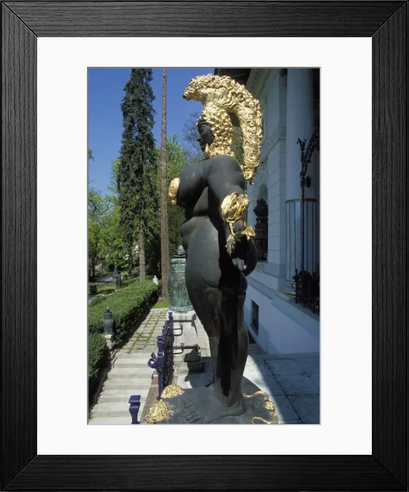Framed Print : Close-up, side view of a female nude statuewith gold headdress in front of the building Framed Print : Close-up, side view of a female nude statuewith gold headdress in front of the building
