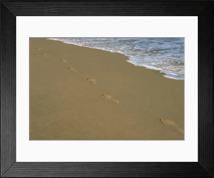Framed Print : Footprints in the sand on a beach and waters edge Framed Print : Footprints in the sand on a beach and waters edge