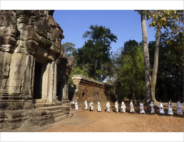 A procession of Buddhist nuns file through the temples of Angkor, UNESCO World Heritage Site