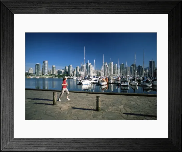 Framed Print : Jogger passing in front of False Creek marina, with downtown skyscrapers behind Framed Print : Jogger passing in front of False Creek marina, with downtown skyscrapers behind