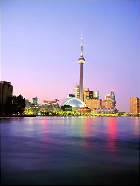 The CN tower rises above the city skyline at dusk, Toronto, Ontario, Canada