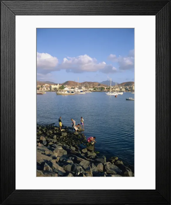 Framed Print : Boys on the rocks, with the harbour and town in the background, at Mindelo Framed Print : Boys on the rocks, with the harbour and town in the background, at Mindelo